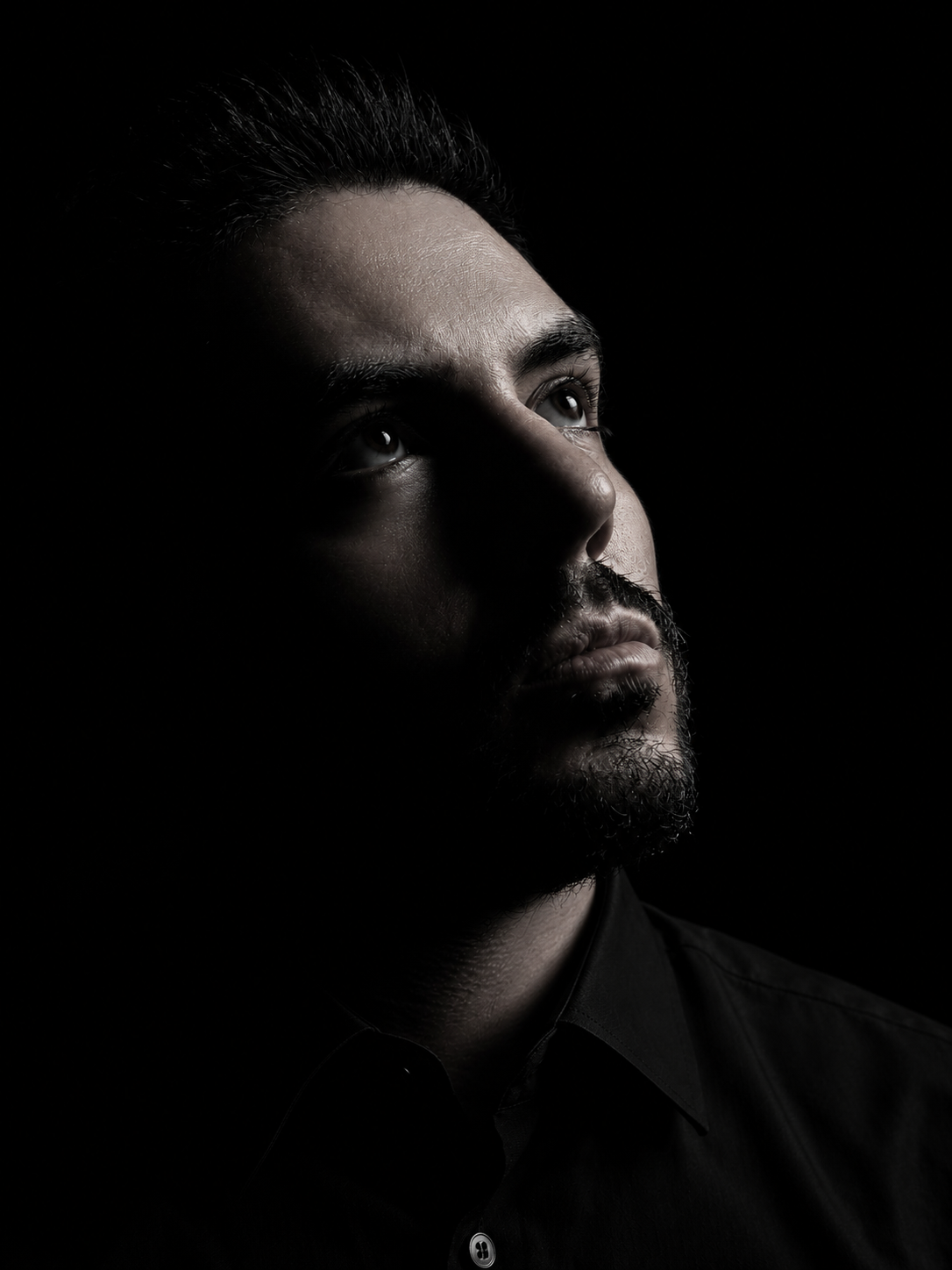 Retrato en clave baja de Dre Rendón sobre fondo negro