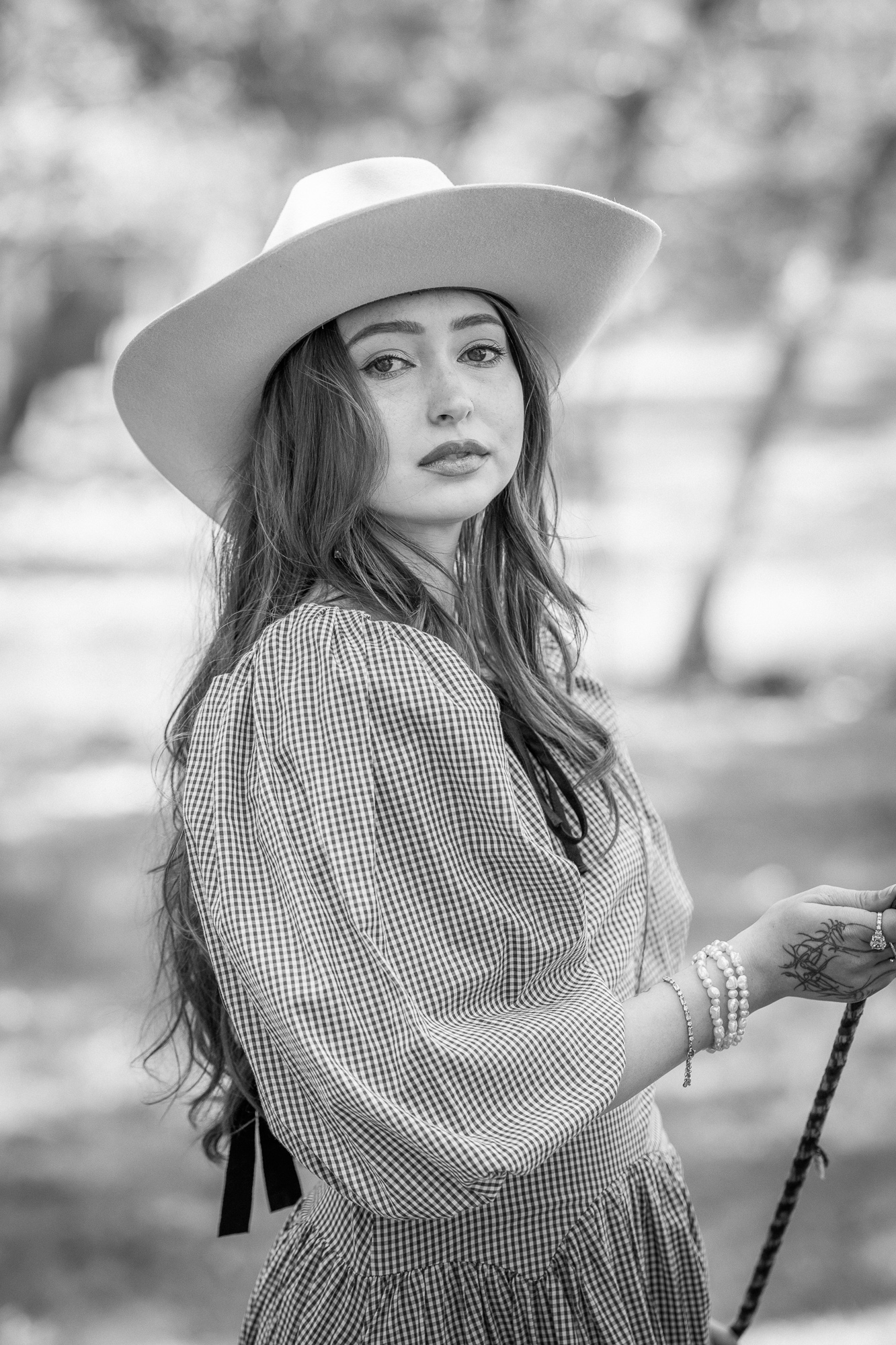 Retrato en blanco y negro de mujer con sombrero de ala ancha y vestido texturizado